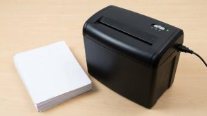 Office worker maintaining a paper shredder safely